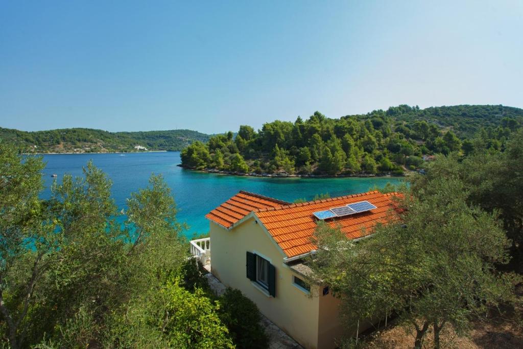 a house with an orange roof next to a lake at Seaside holiday house Cove Gabrica, Korcula - 17195 in Vela Luka