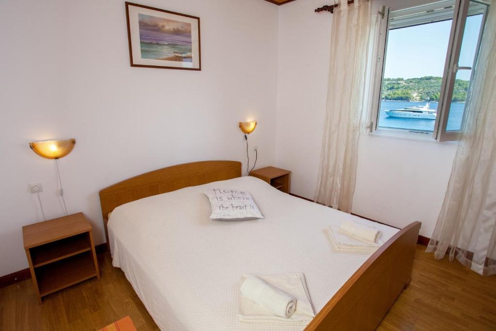 a bedroom with a white bed and a window at Seaside holiday house Cove Gabrica, Korcula - 17195 in Vela Luka
