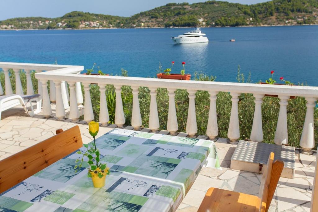 a table and chairs on a balcony with a view of the water at Seaside holiday house Cove Gabrica, Korcula - 17195 in Vela Luka