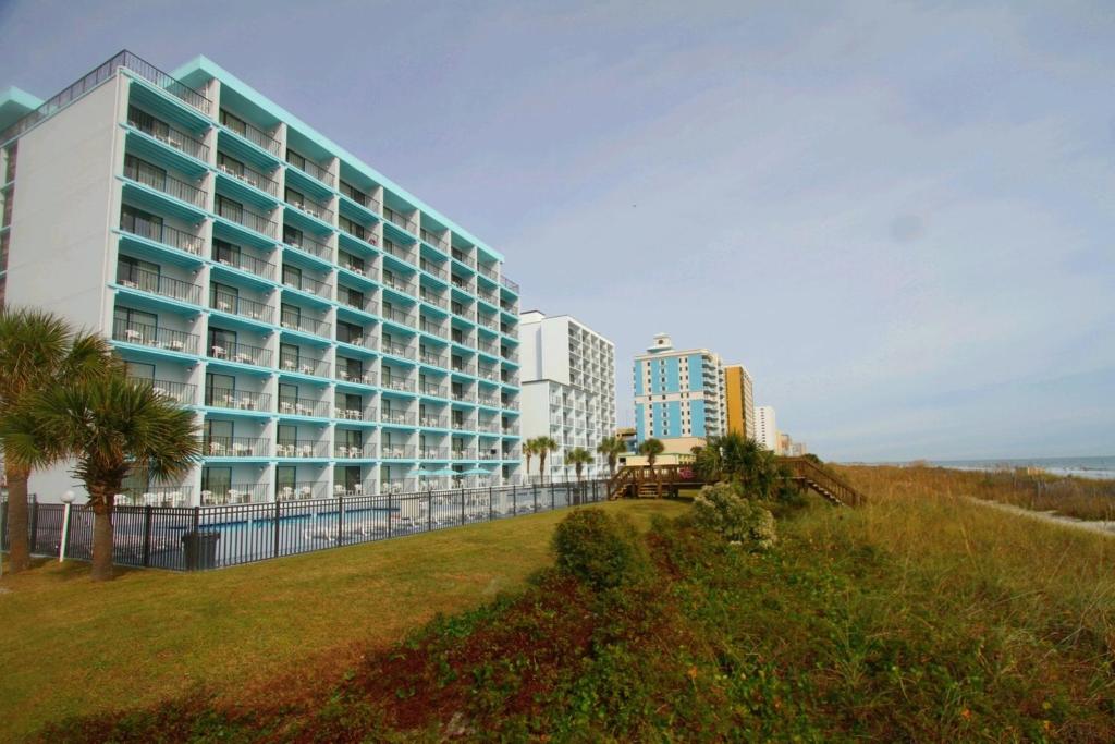 ein großes Gebäude am Strand mit Palmen in der Unterkunft Tropical Seas Hotel in Myrtle Beach