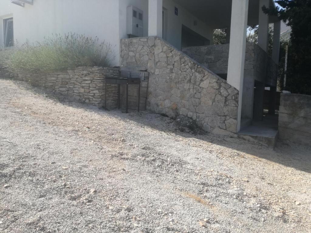 a stone wall in front of a house at Apartments by the sea Zatoglav, Rogoznica - 17321 in Rogoznica