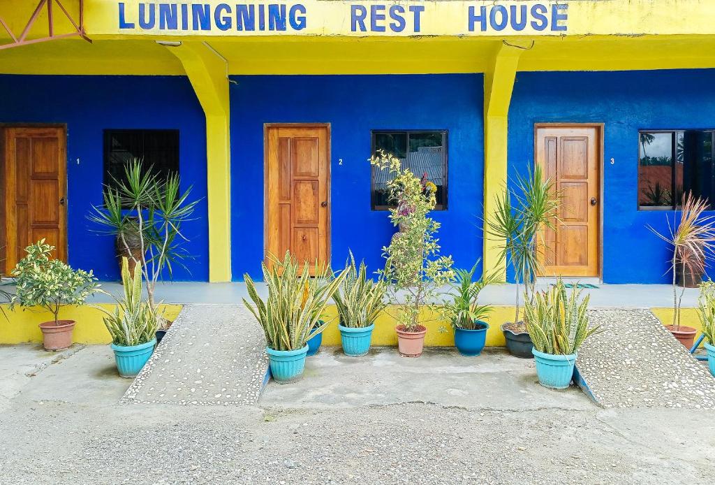 un bâtiment bleu avec des plantes en pot devant lui dans l'établissement Erojo's Beach Resort, à Sindangan