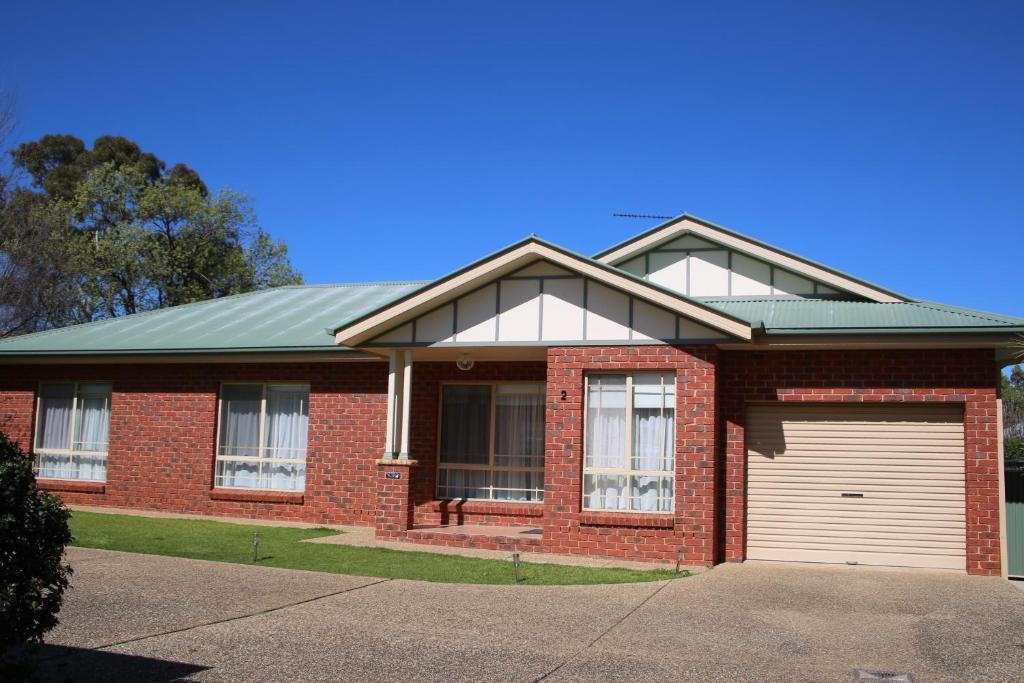 a red brick house with a white garage at Wagga Showground Villas in Wagga Wagga