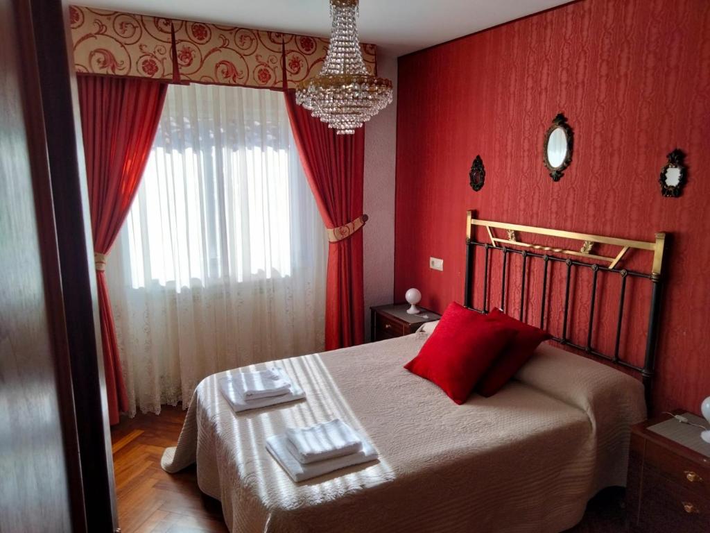 1 dormitorio con paredes rojas y 1 cama con almohadas rojas en Casa Navacastellanos, en Casarejos