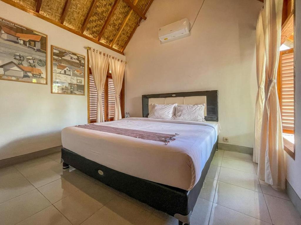 a bedroom with a large bed in a room at Aira Homestay near Pantai Kuta Mandalika Mitra RedDoorz in Bumbang