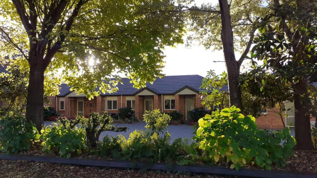 a house with a lot of trees and plants at Northwood Motor Lodge in Christchurch