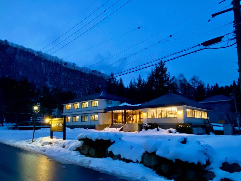 Una casa en la nieve por la noche en Hakuba Park Hotel, en Hakuba