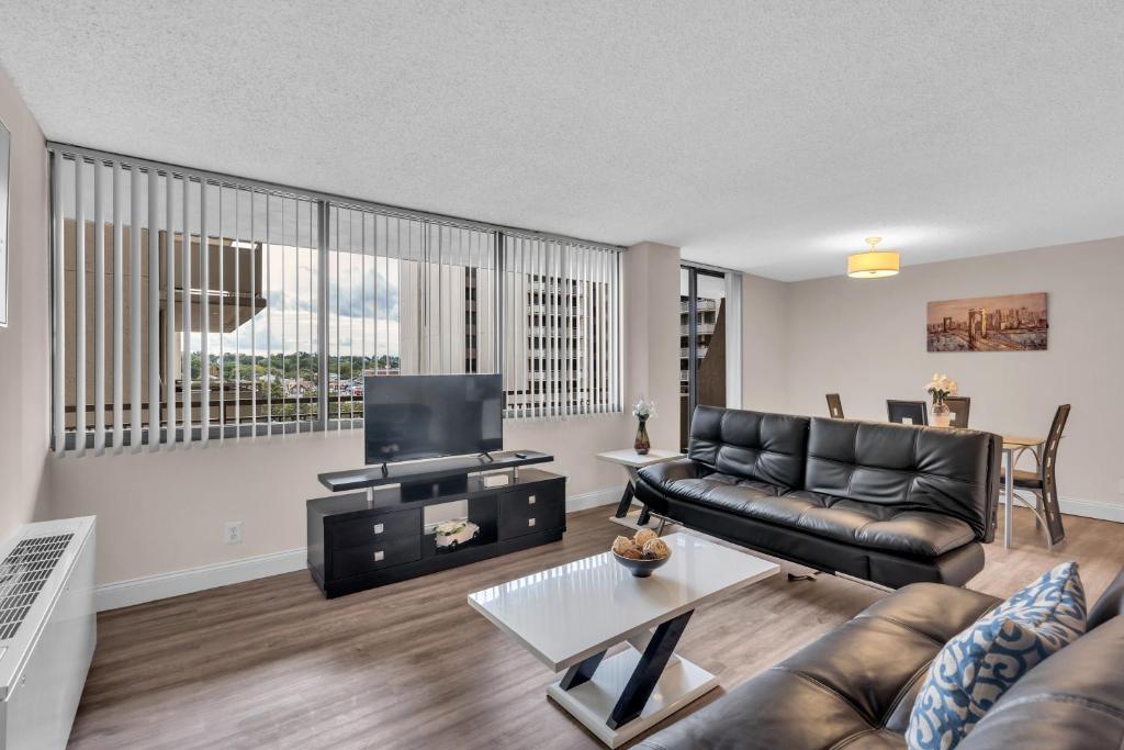 a living room with a couch and a tv at Arlington Fully Furnished Apartments in Crystal City in Arlington