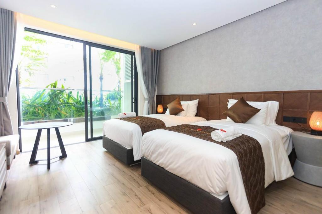 um quarto de hotel com duas camas e uma grande janela em Apec Mandala Wonder em Tuy Hoa