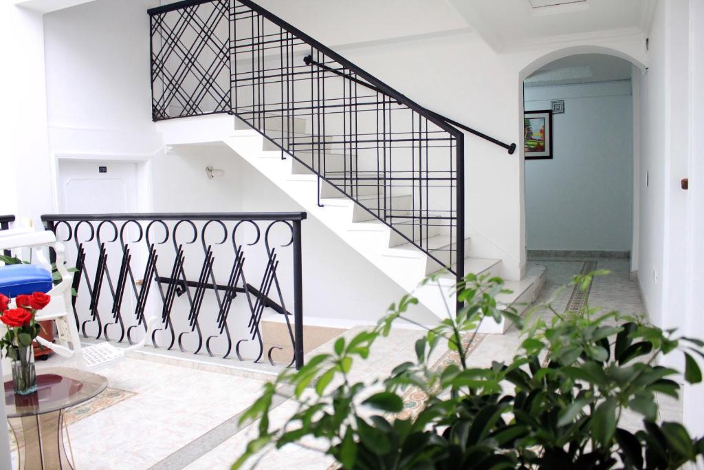 a staircase in a house with a black railing at Hotel Ecoinn in Bogotá