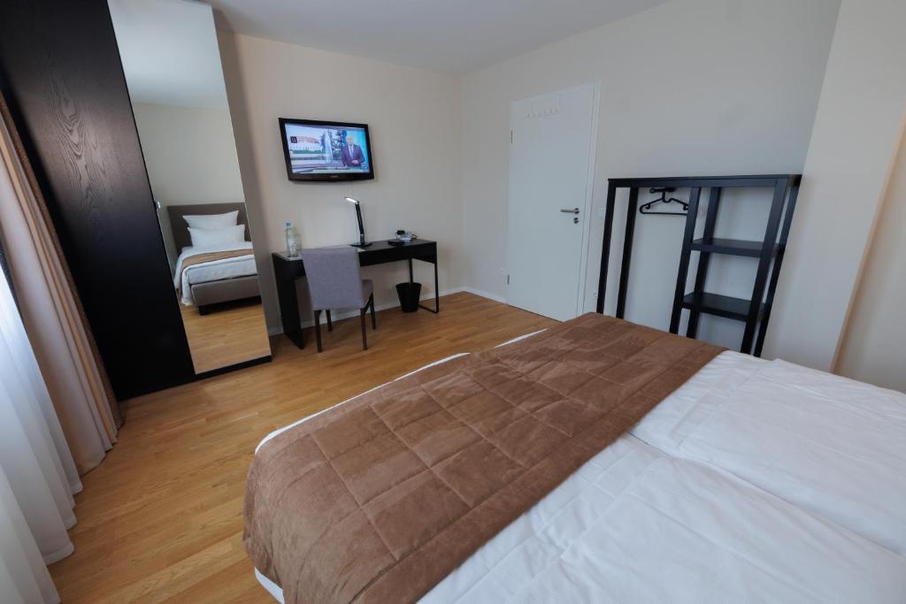 a bedroom with a bed and a desk and a chair at Hotel Jellentrup in Münster