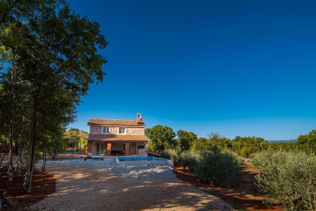 dom na środku pola z drzewami w obiekcie Luxury villa with a swimming pool Risika, Krk - 17410 w mieście Vrbnik
