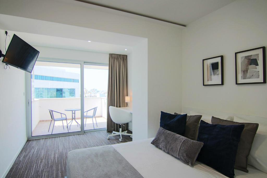 ニコシアにあるPhaedrus Living: Luxury Suite Nicosia 506のベッドルーム1室(ベッド1台付)、バルコニー(テーブル付)