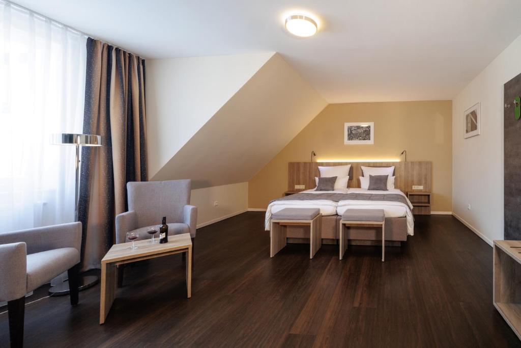 a bedroom with a bed and two chairs and a couch at Hotel Jellentrup in Münster