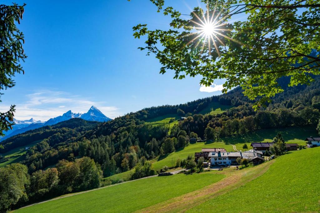 wioska w górach ze słońcem na niebie w obiekcie Bauernhof Vorderstiedler w mieście Berchtesgaden