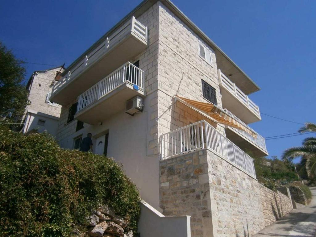 a building with balconies on the side of it at Apartments by the sea Povlja, Brac - 17472 in Povlja