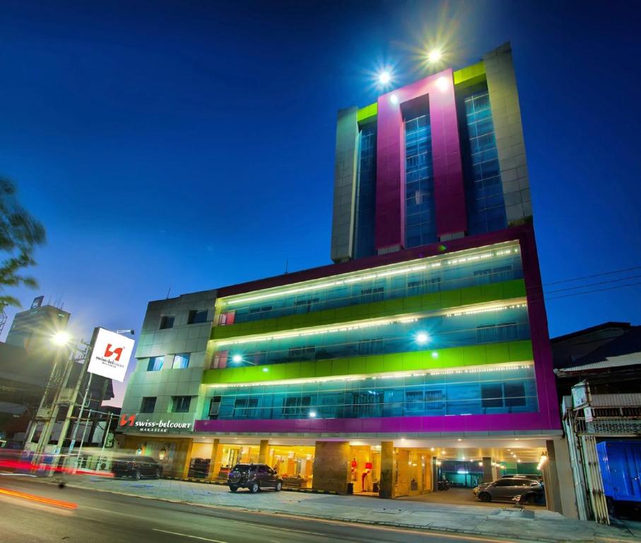 a large building with colorful windows on a city street at Swiss-Belcourt Makassar in Makassar