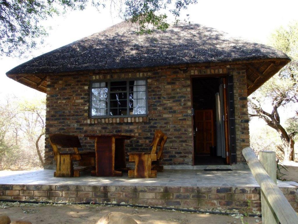 una piccola casa in mattoni con tavolo e sedie di Mkolo Hunting and Wildlife 