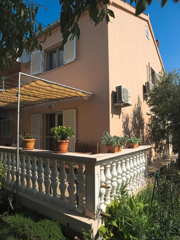 a house with a white fence and potted plants at Apartments with a parking space Betina, Murter - 17478 in Betina