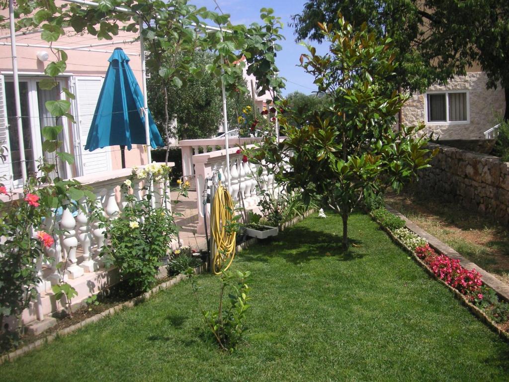 a garden with an umbrella and a fence at Apartments with a parking space Betina, Murter - 17478 in Betina