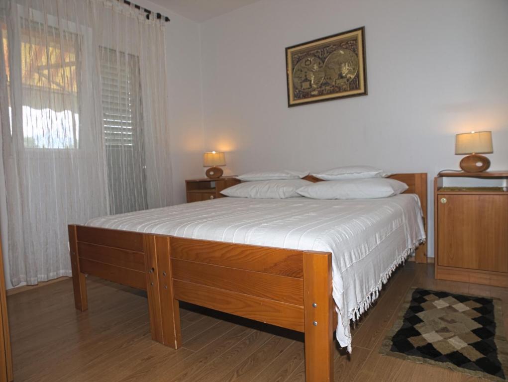 a bedroom with a bed with white sheets and a window at Apartments with a parking space Betina, Murter - 17478 in Betina