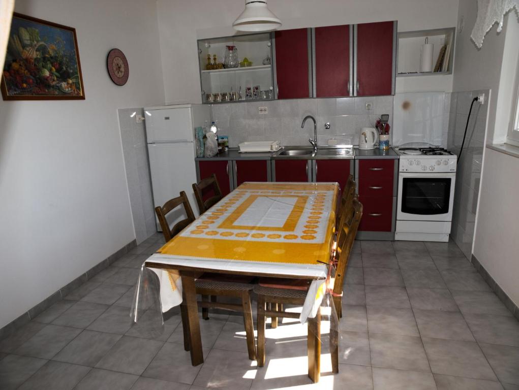 a kitchen with a table and chairs and a sink at Apartments with a parking space Betina, Murter - 17478 in Betina