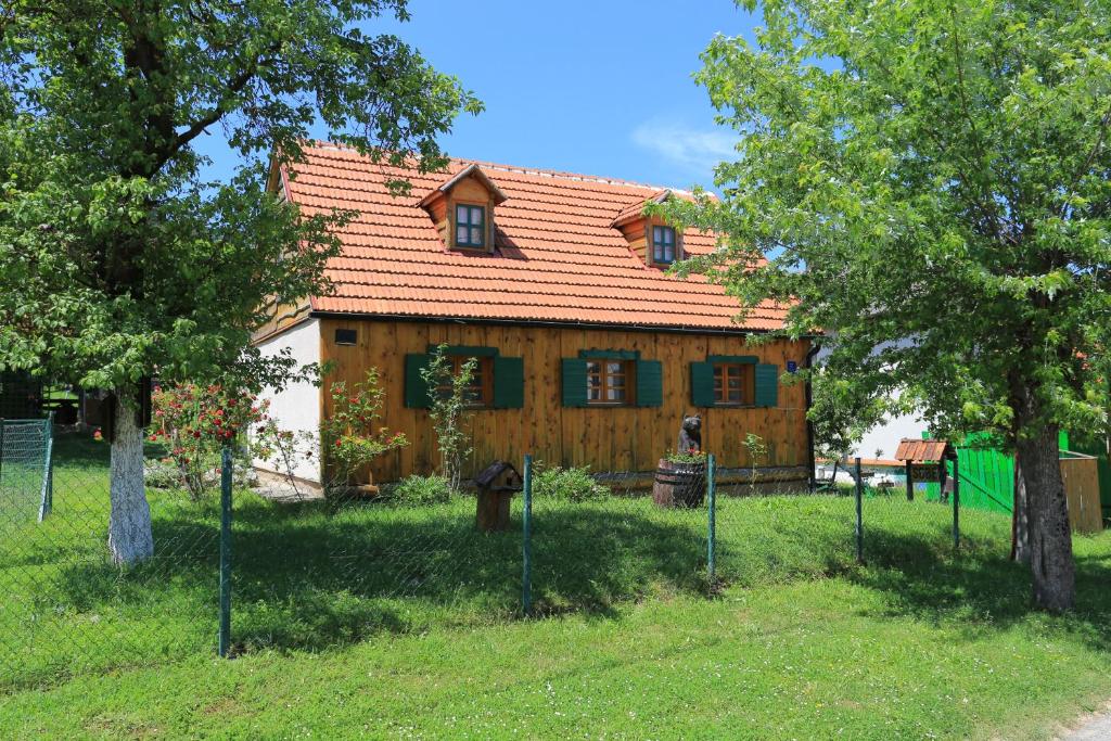 a wooden house with a red roof in a yard at Apartments for families with children Perusic (Velebit) - 17540 in Perušić