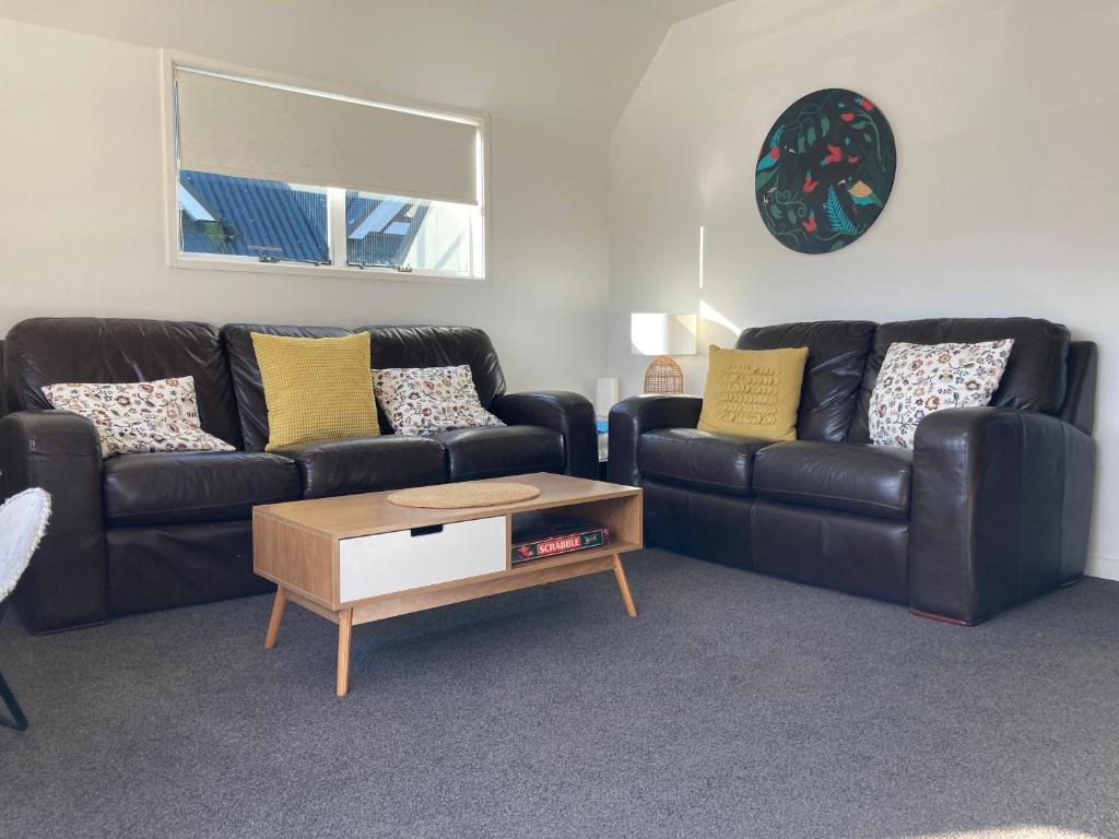 a living room with two leather couches and a coffee table at Heart of Russell Apartment - Russell Apartment in Russell