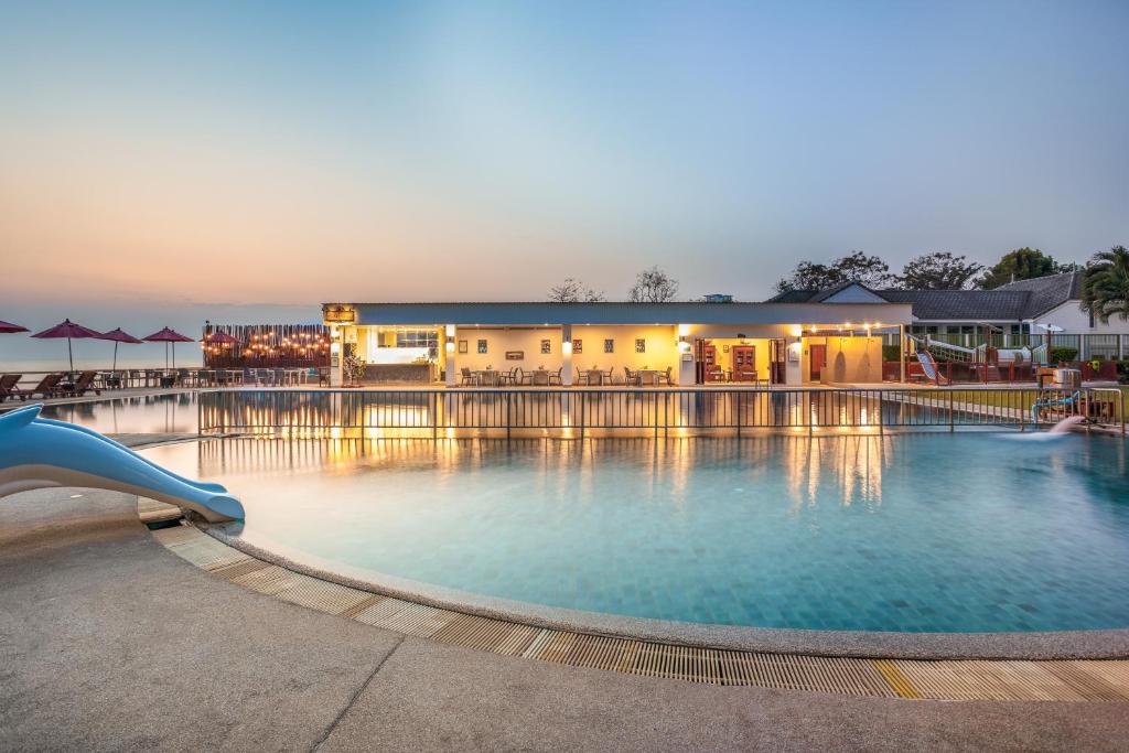 uma piscina com escorrega em frente a um hotel em Chom View Hotel, Hua Hin em Hua Hin