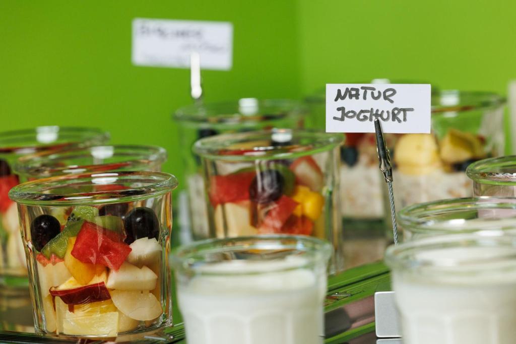 a bunch of glass jars filled with fruit and yogurt at Hotel Jellentrup in Münster