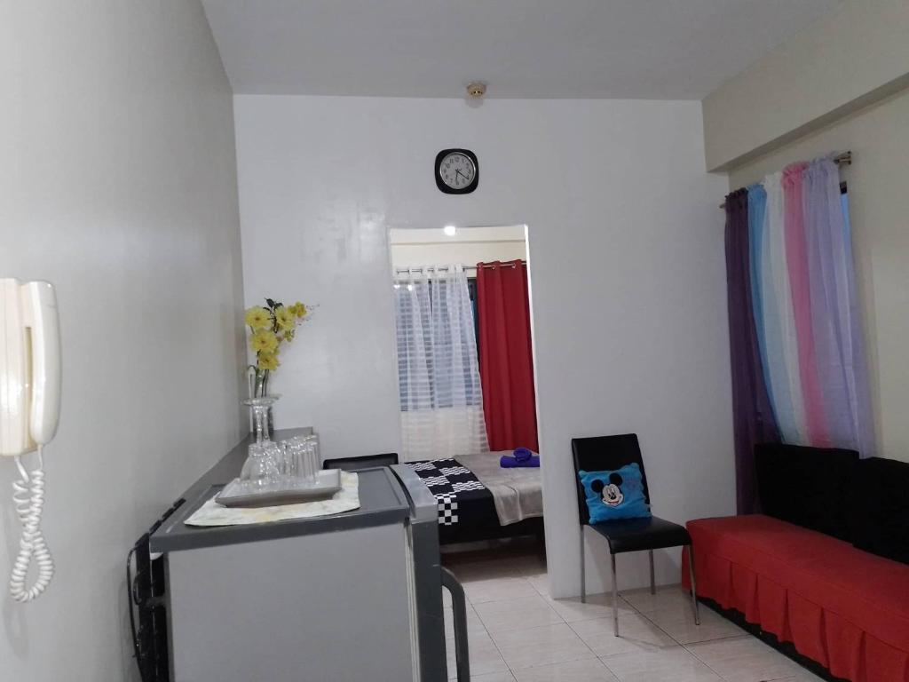 ein Wohnzimmer mit einem roten Sofa und einem Bett in der Unterkunft Pet Friendly Staycation near Villa Ardin in Cainta