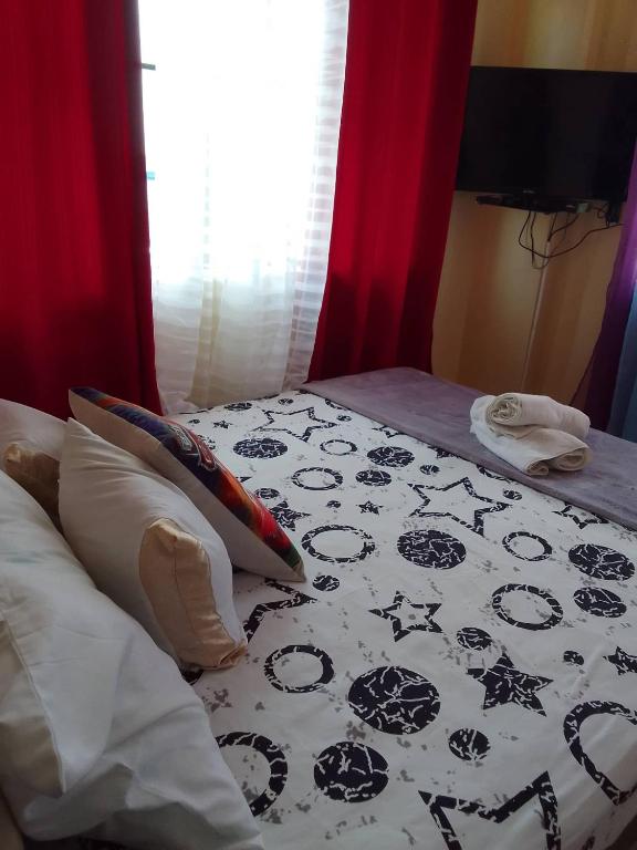 a bed with a black and white comforter on it at Pet Friendly Transient along Ortigas Ext in Cainta