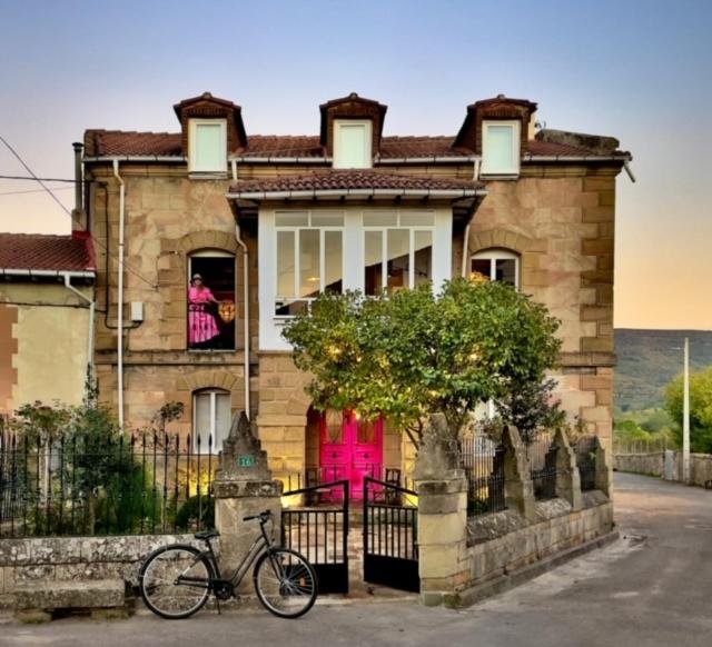 una bicicleta estacionada frente a una casa con una puerta rosa en Casa Pepin, en Polientes