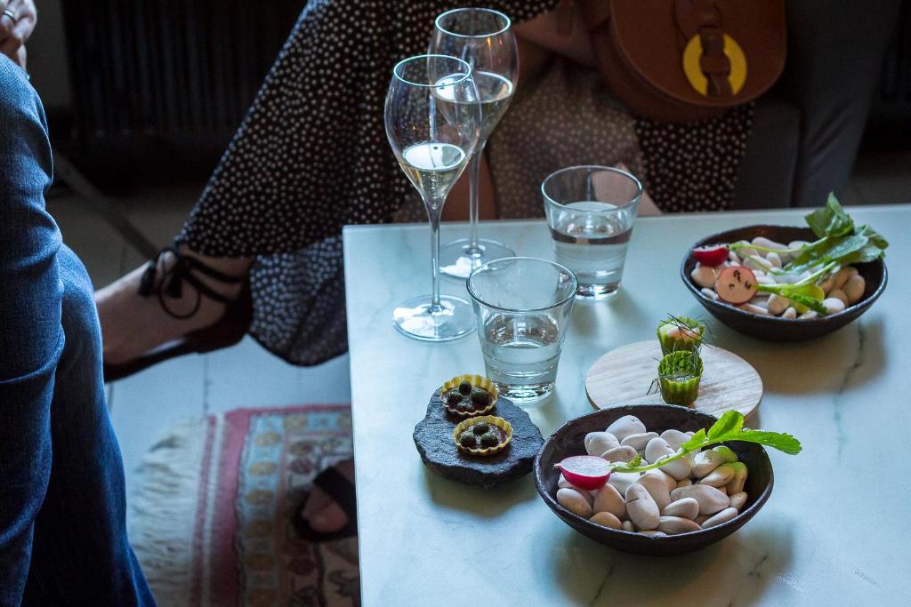 a table with two glasses of wine and a plate of food at Hotel Onni in Porvoo