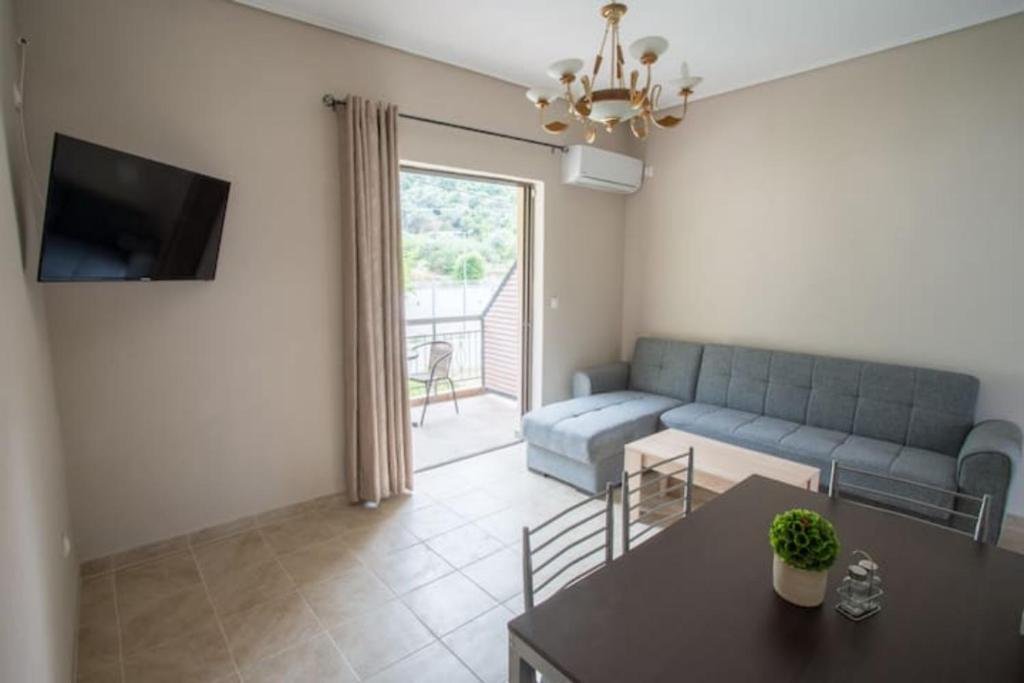 a living room with a blue couch and a table at Vasileiou Apartments in Kamena Vourla