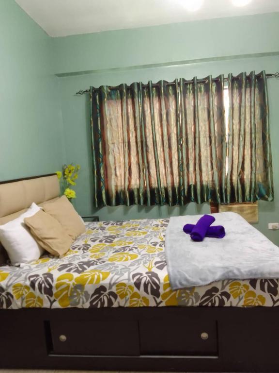 a bedroom with a bed with a purple stuffed animal on it at Affordable Transient in Valley Golf near Emperor Events Place in Cainta