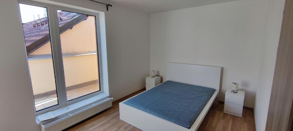 sypialnia z łóżkiem i dużym oknem w obiekcie One bedroom penthouse apartment # 82 in the brand new building close to the city center with free parking w Pradze