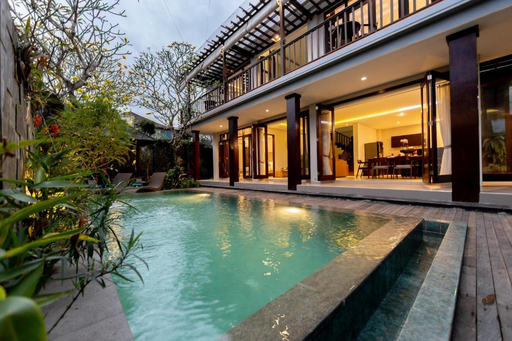 a swimming pool in front of a house at Green Oasis Private Villa in Ubud