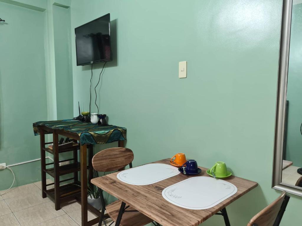ein Zimmer mit Tisch und Stühlen und einem Fernseher in der Unterkunft Affordable Condo for Rent along Ortigas Extension in Cainta