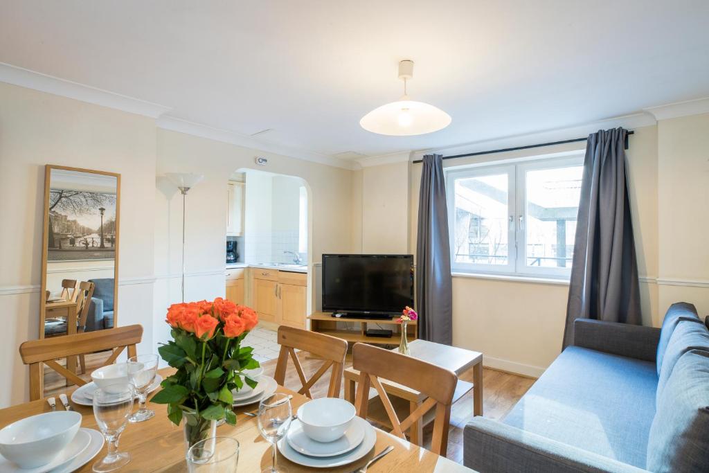 a living room with a blue couch and a table at Stay Saint Paul's in London