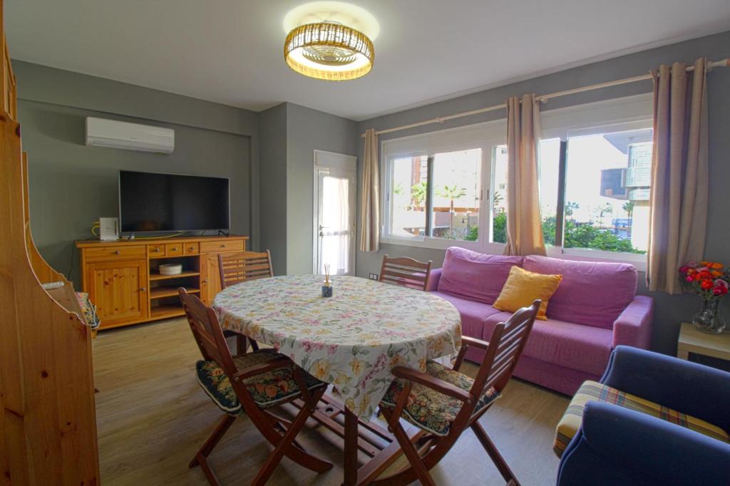 - un salon avec une table et un canapé violet dans l'établissement Fuengirola, sol y playa., à Fuengirola