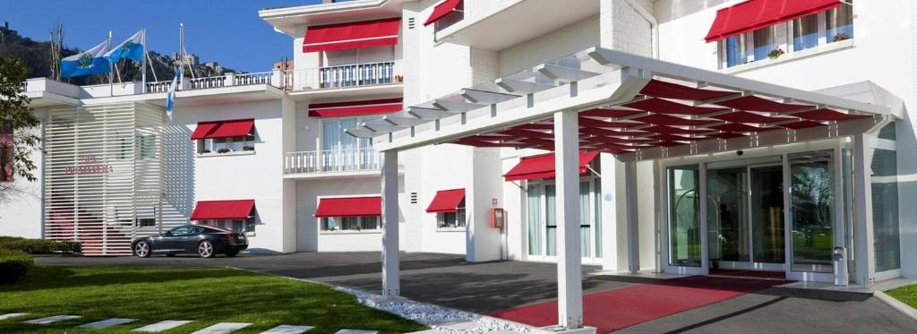 a building with red awnings on the front of it at The Regent Boutique Hotel & Spa PRE OPENING in San Marino