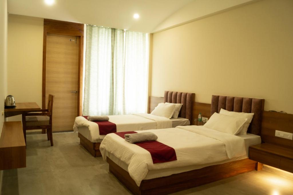 GolāghātにあるChang's Garden & Resortのベッド2台とデスクが備わるホテルルームです。