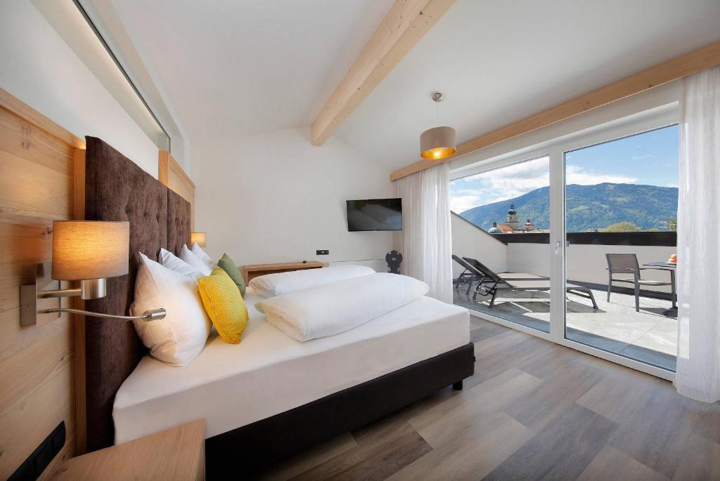 um quarto com uma cama e vista para uma varanda em Appartement-Hotel Anthea em Tirolo