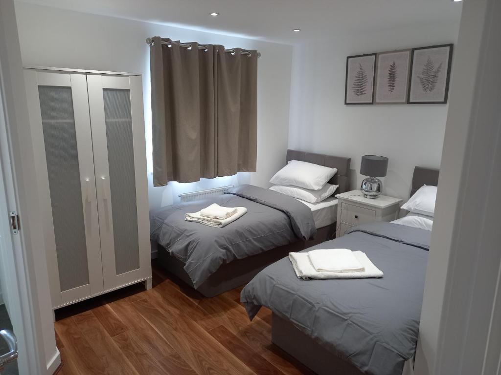 1 dormitorio con 2 camas y toallas. en Modern home with Netflix, NowTV & 2private parking en East Tilbury