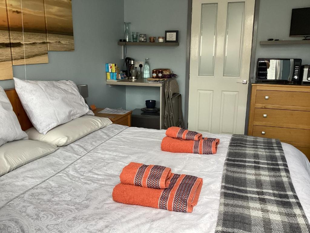 ein Schlafzimmer mit einem Bett mit zwei Kissen darauf in der Unterkunft The Den at Pinchbeck in Spalding