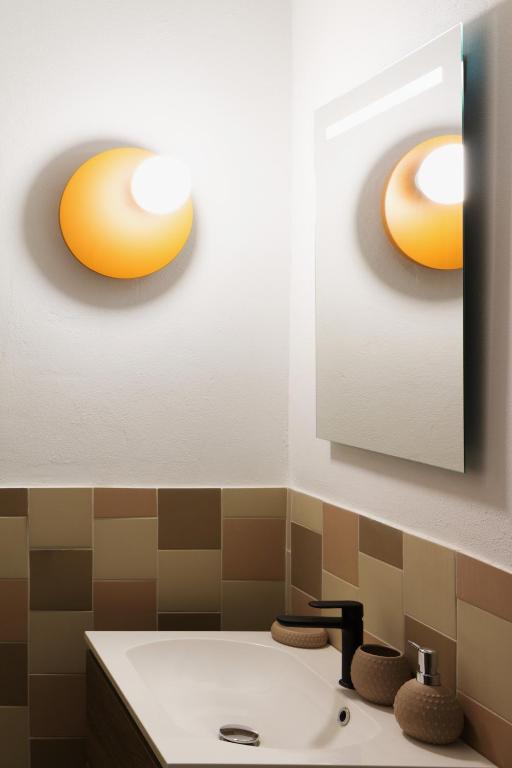 łazienka z umywalką i 2 lampkami na ścianie w obiekcie JOIVY Smart 1-bed with modern amenities w Mediolanie