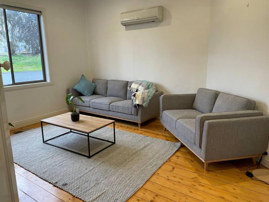 a living room with two couches and a coffee table at Walnut House - Hargreaves St close to Lake Weeroona in Bendigo