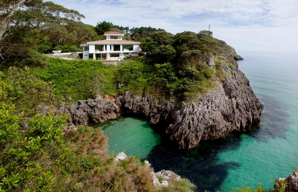 a house on a cliff above the ocean at La Península, exclusiva villa Wishome sobre el mar en Cantabria in Pechón