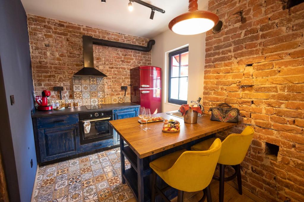 a kitchen with a wooden table and a brick wall at NOMAD STUDIOS, Kapana in Plovdiv